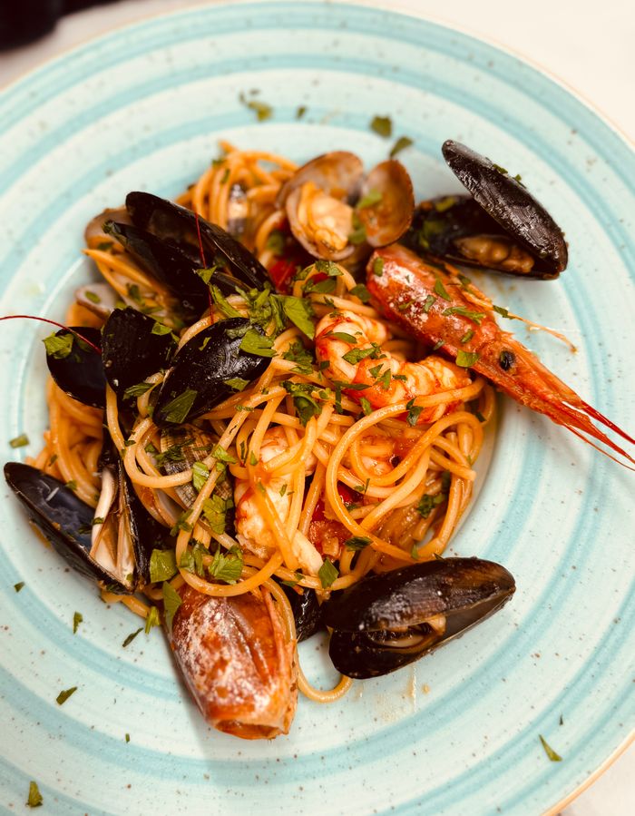 services-bg Tantalizing seafood spaghetti with mussels and shrimp, elegantly served on a white plate. Perfect for gourmet dining visuals.